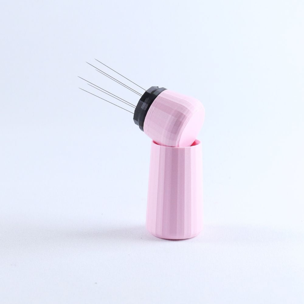 Pink acupuncture needle holder with needles on a light gray background