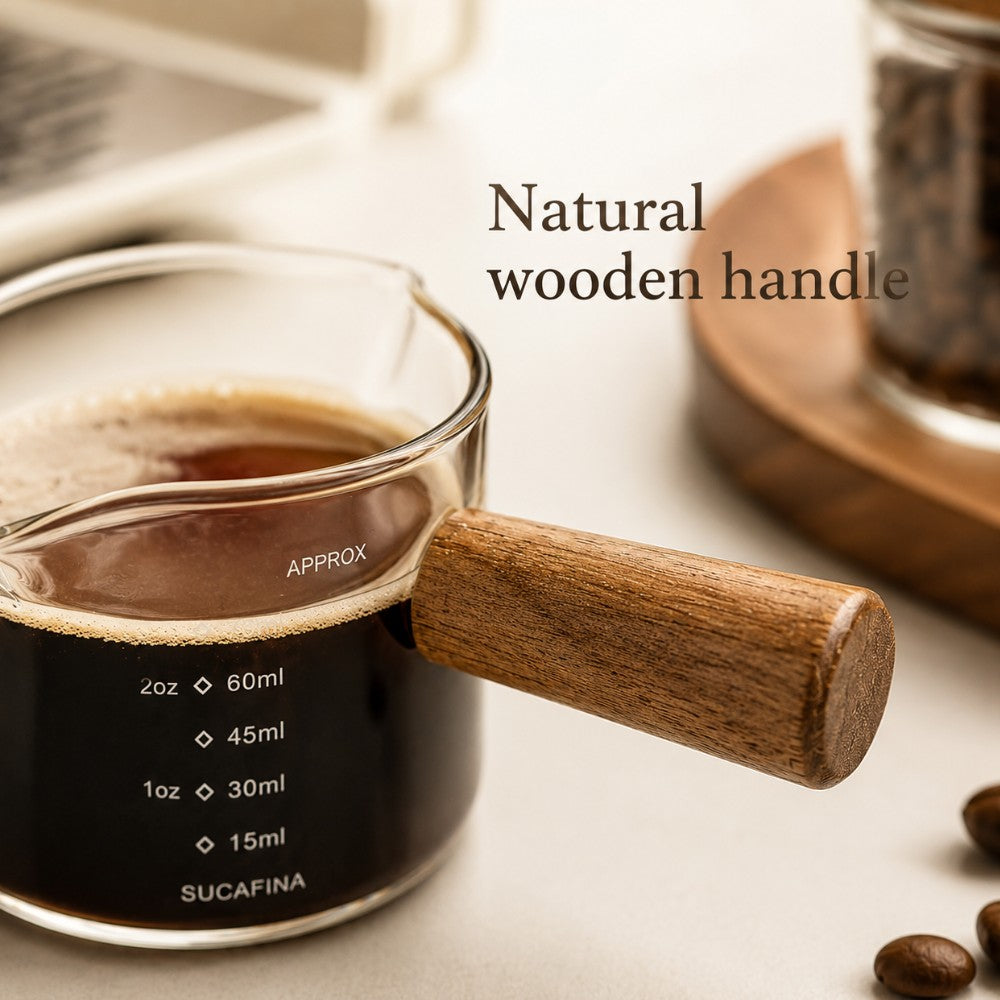 Natural wooden handle detail on glass espresso measuring cup