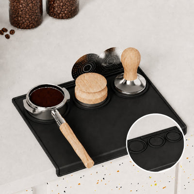 Espresso tools organised on black silicone tamping mat with portafilter and tamper
