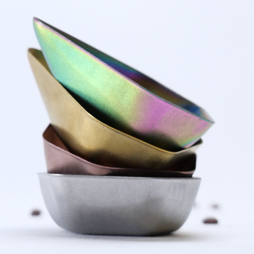 Stack of metallic bowls with iridescent finish on a white background