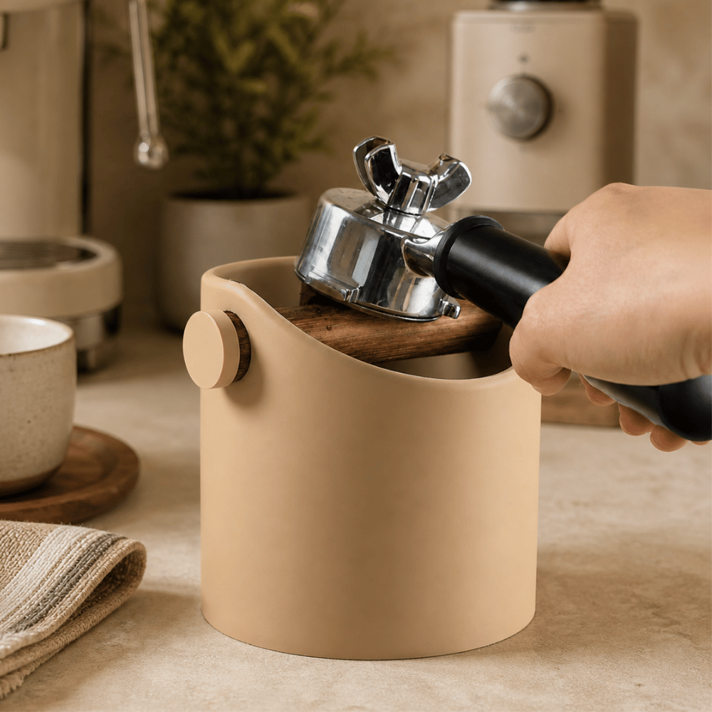Person using a manual coffee grinder in a kitchen setting