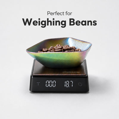 Digital espresso scale with a colorful bowl containing beans on a white background