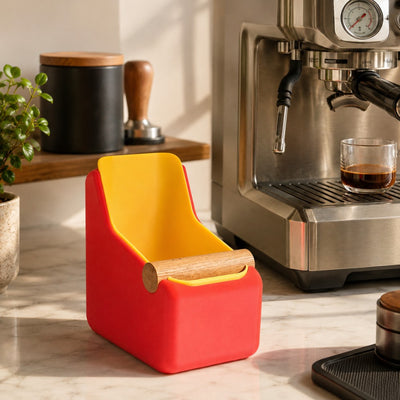 Red and yellow container on a kitchen counter next to an espresso machine.