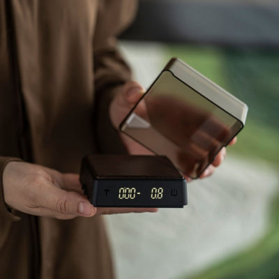Compact coffee scale with removable tray held by hand