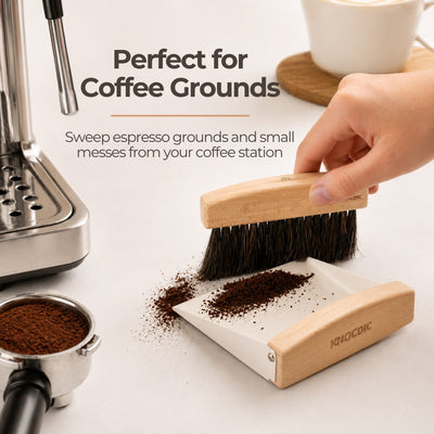 Wooden coffee brush being used to sweep espresso grounds from a coffee station.