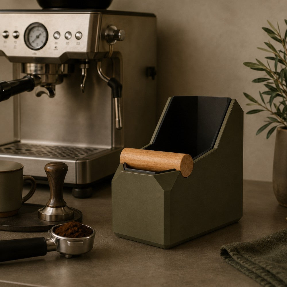 Olive green KNOCDIC knock box with wooden knock bar beside espresso machine and coffee accessories