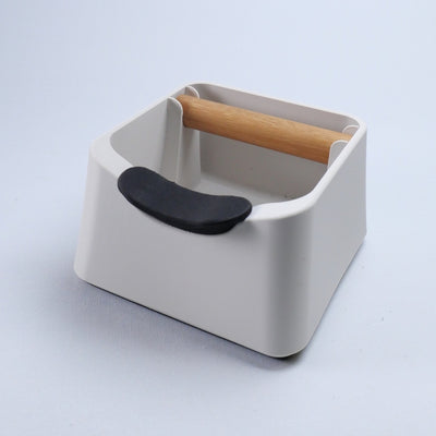 KNOCDIC The Pod 3-in-1 espresso knock box and tamping station in matte white featuring an integrated carbon fibre portafilter stand and oak bar.