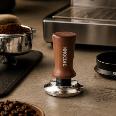 Espresso tamper beside portafilter dosing funnel WDT tool puck screen and coffee beans