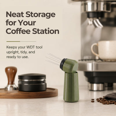 An olive green espresso needle distribution tool resting on a kitchen coffee station counter beside a tamping mat.