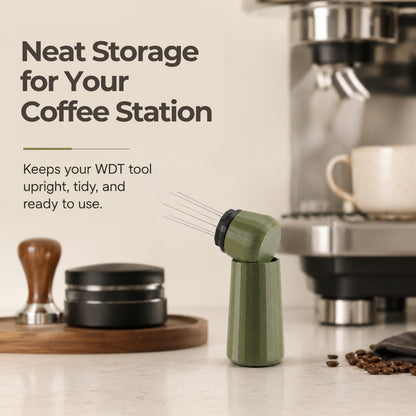 An olive green espresso needle distribution tool resting on a kitchen coffee station counter beside a tamping mat.